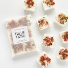 packet of wax melts and loose wax melts decorated with dried botanicals