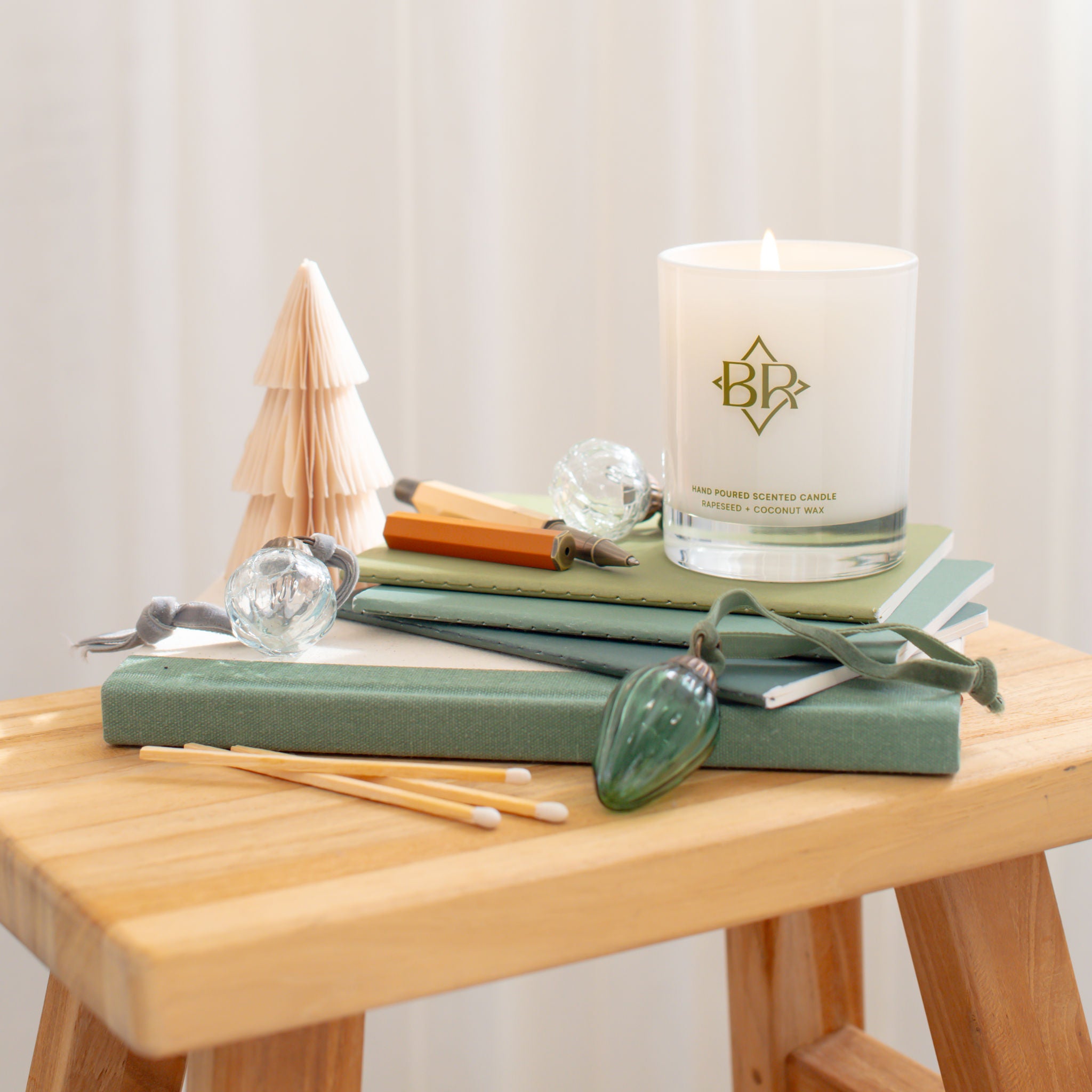 lit candle on books with christmas decorations