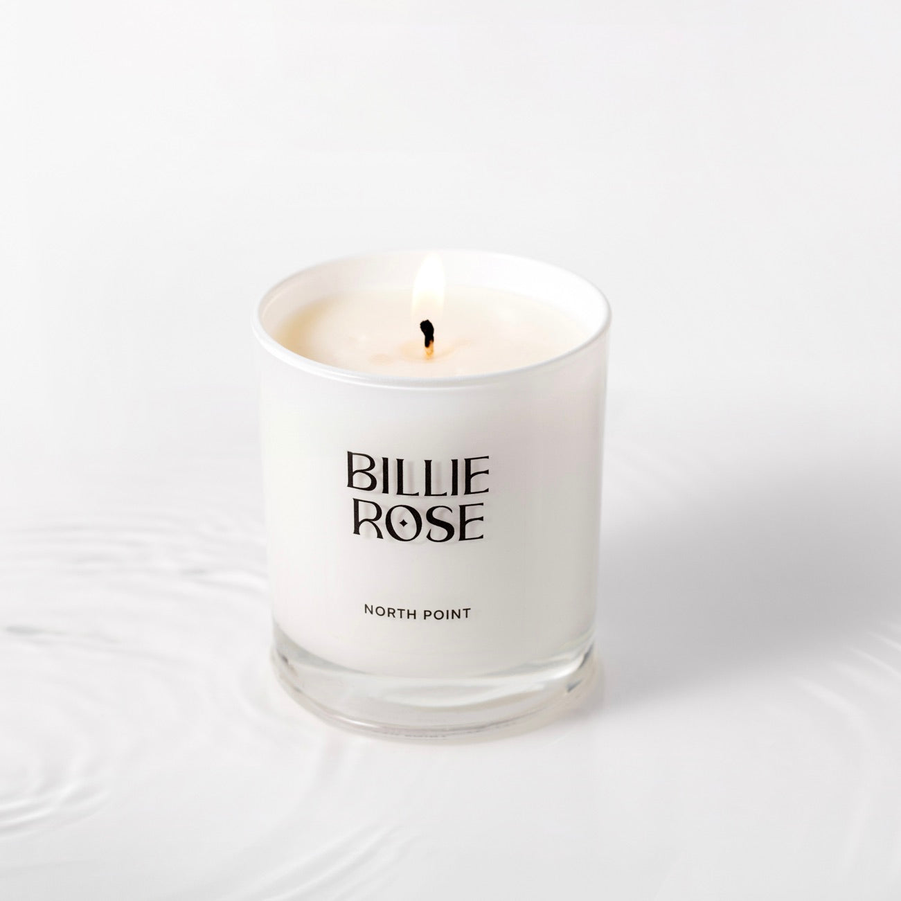 North Point candle on plain background with water ripples