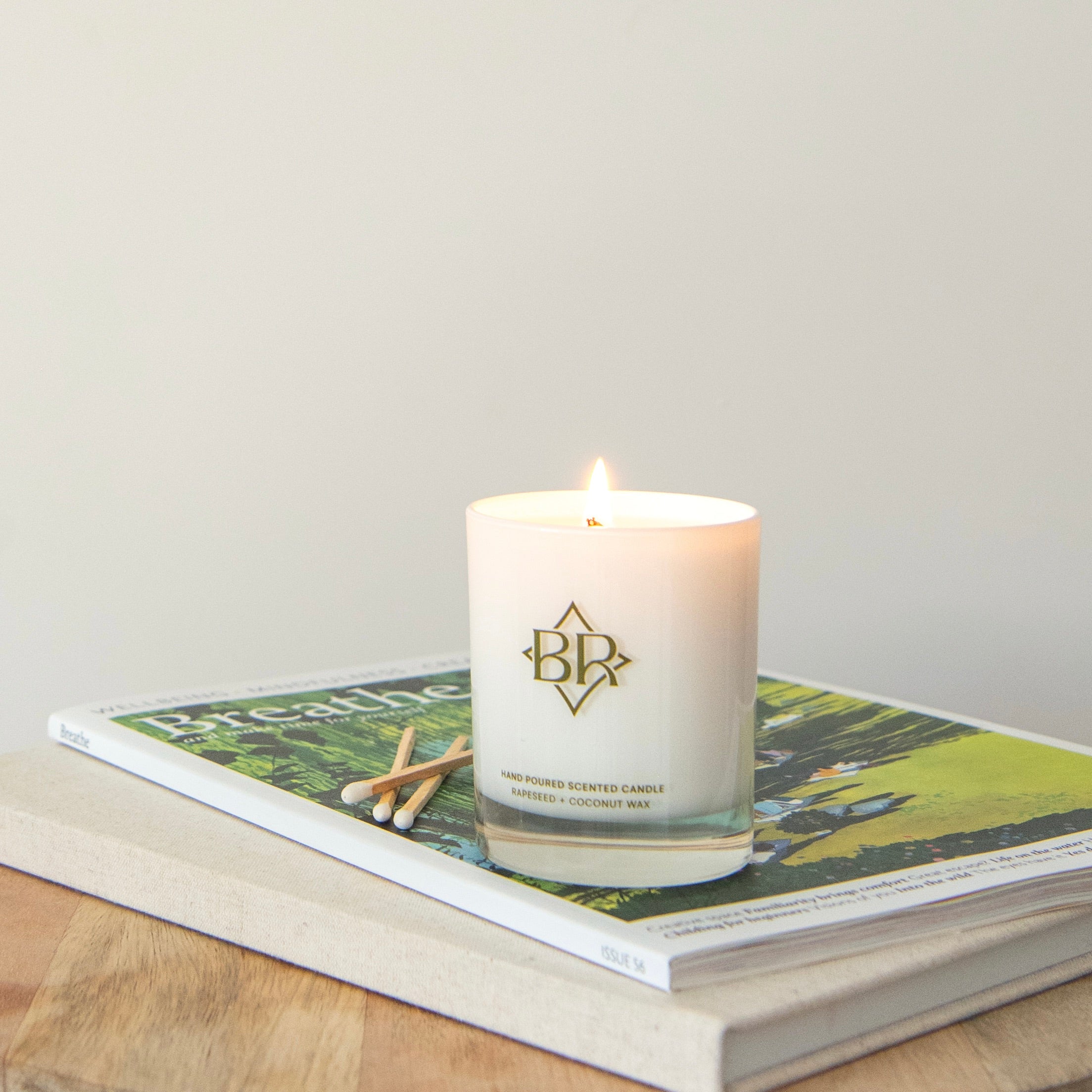 lit candle displayed on some books with matches at the side