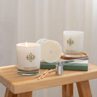 3 candles displayed on wood stand, candle snuffer and matches